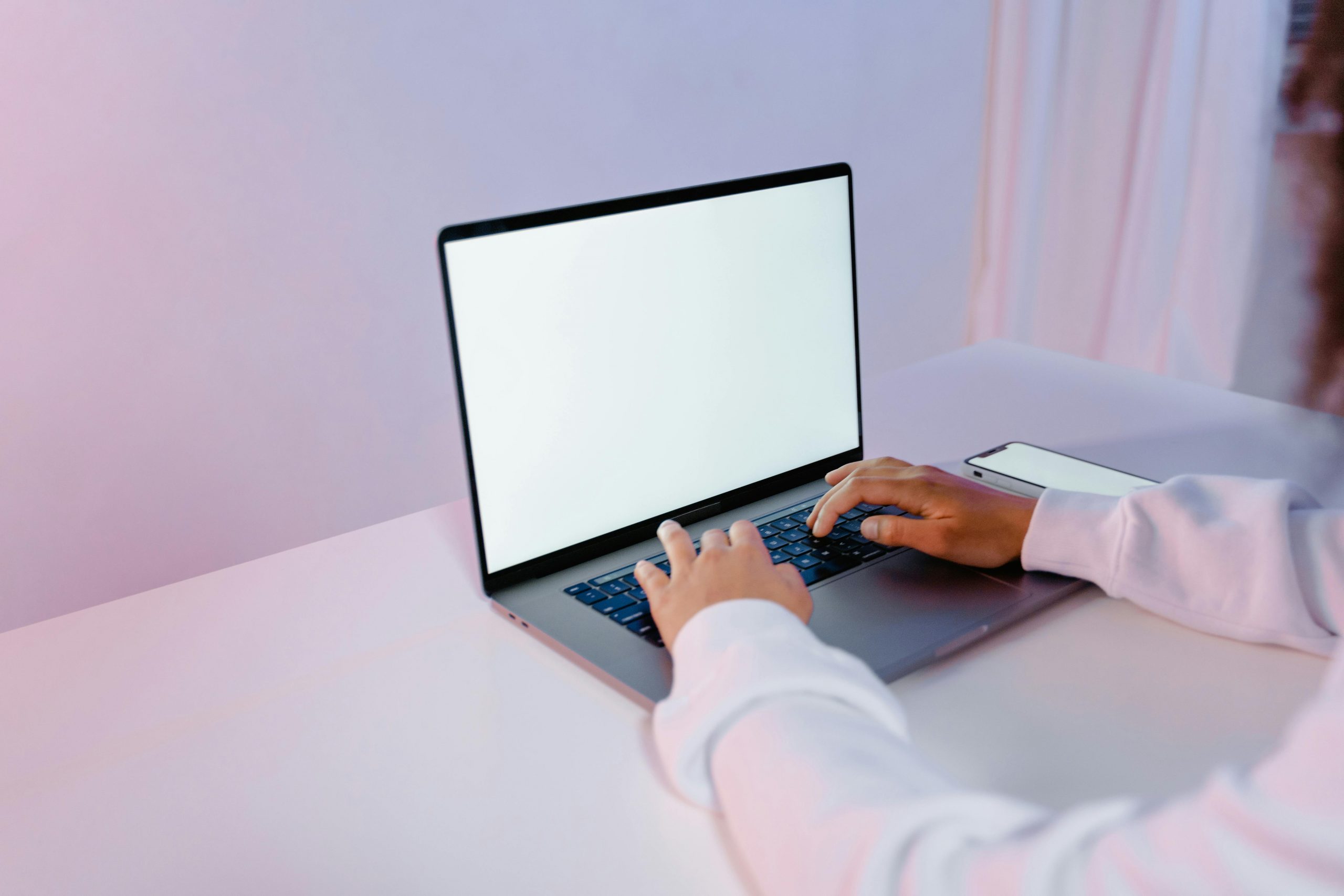 woman typing on a laptop with a blank screen