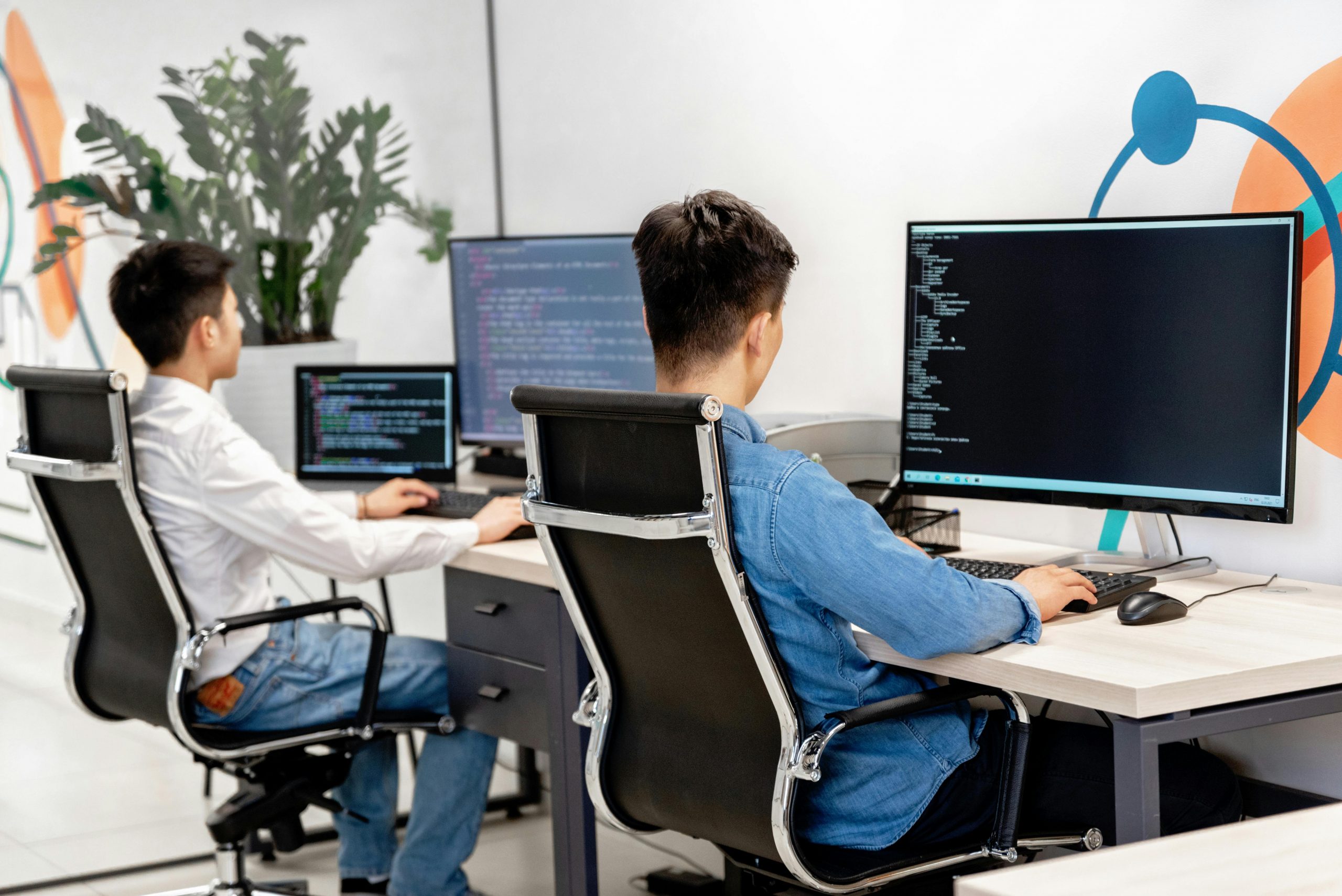 two employees working on desktop computers in the office