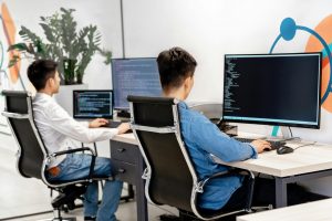 two employees working on desktop computers in the office
